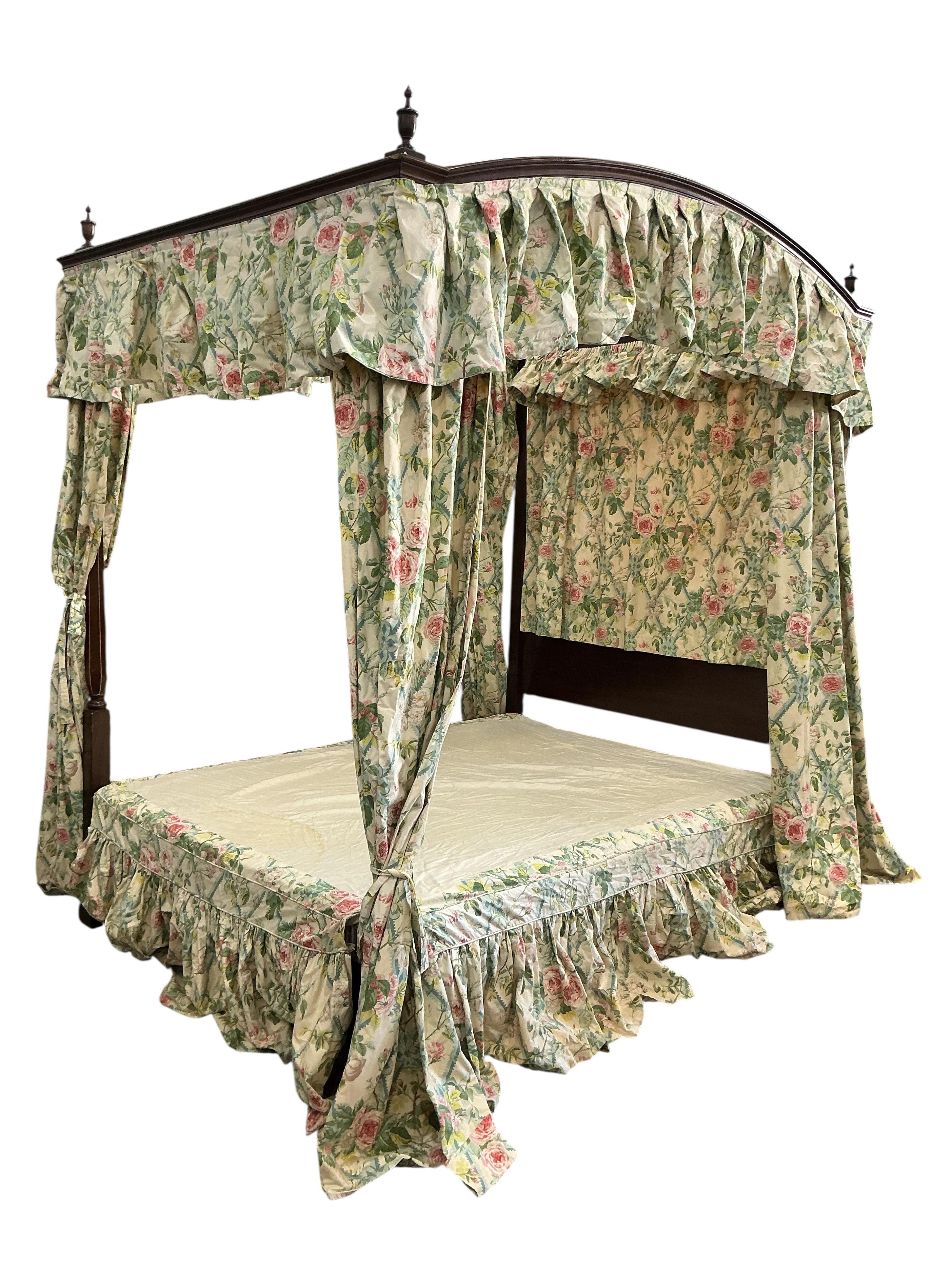 A George III style mahogany four poster bed, with floral drapes, width 150cm, length 208cm, height 220cm